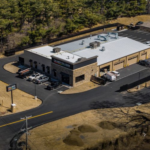 Aerial view of commercial facility with surrounding lot and utility infrastructure