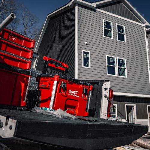 Red tool storage setup on service truck at residential construction site