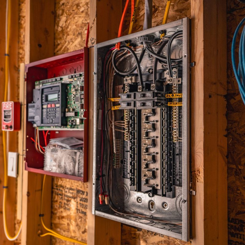In-progress residential electrical panel and control box installation on open framing