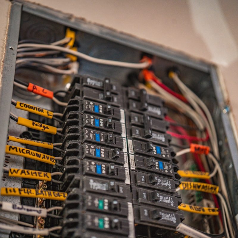 Close-up of residential electrical breaker panel with labeled circuits and wiring