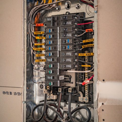 Interior view of residential electrical breaker panel with labeled circuits